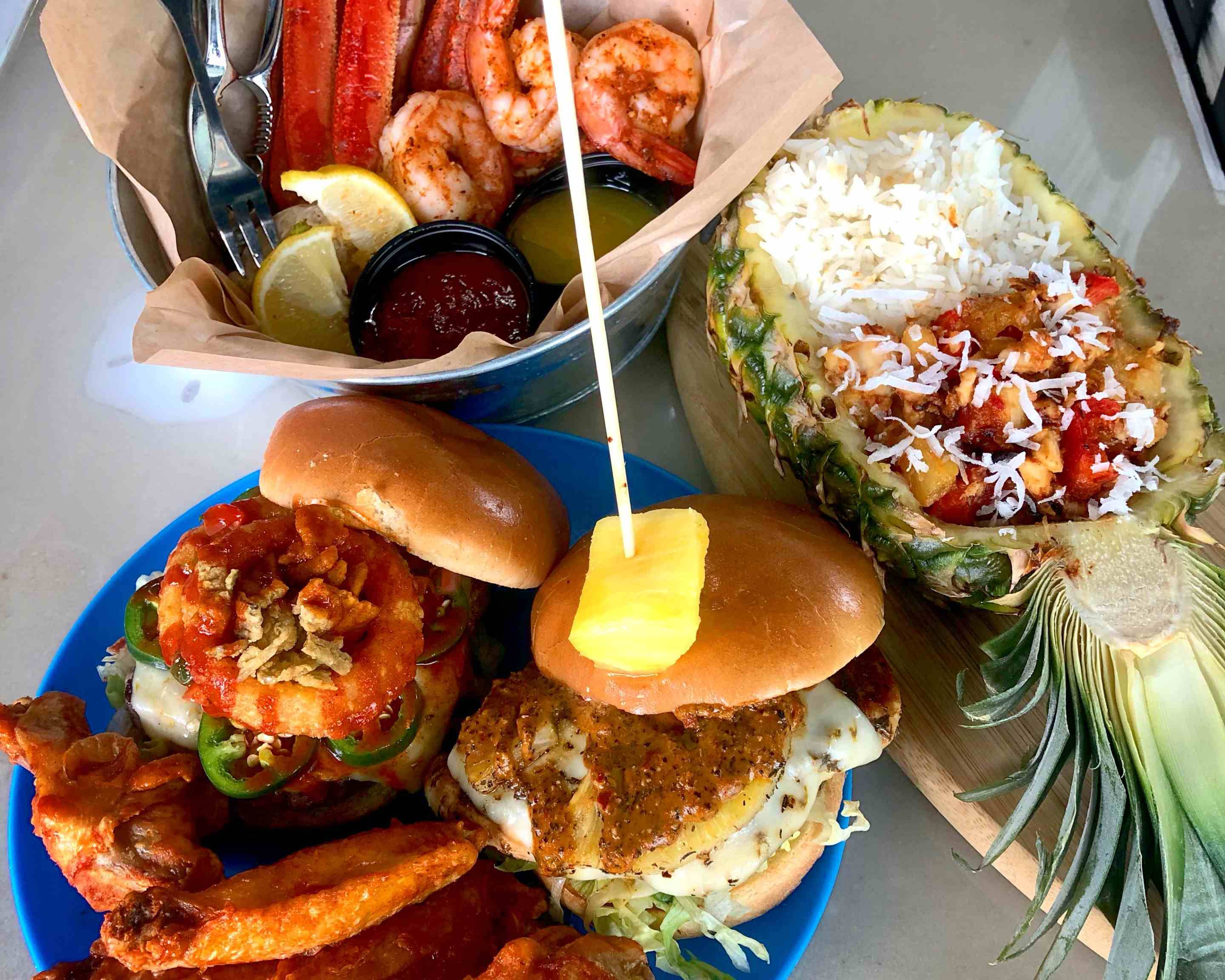 Menu item: burger with sides of shrip and pineapple with chicken.